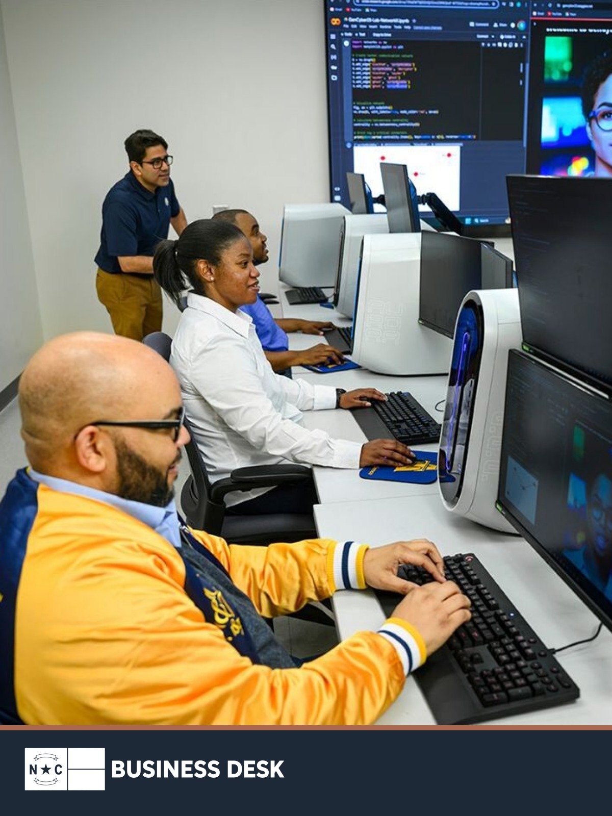N.C. A&T computer science chair Kaushik Roy stands with engineering students working at computers.