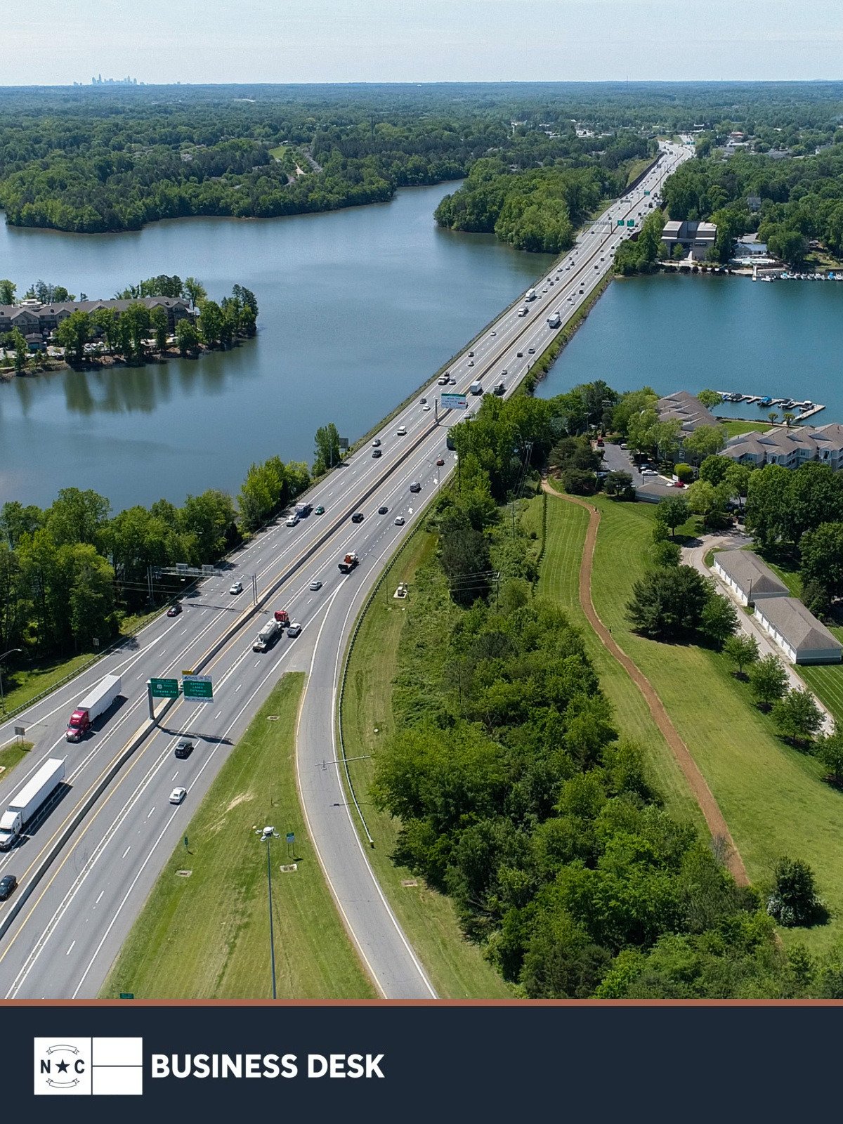 Aerial file photograph of existing I-77 Express Lanes in the Charlotte area above the NC Business Desk footer; the image does not depict the proposed I-77 South action.