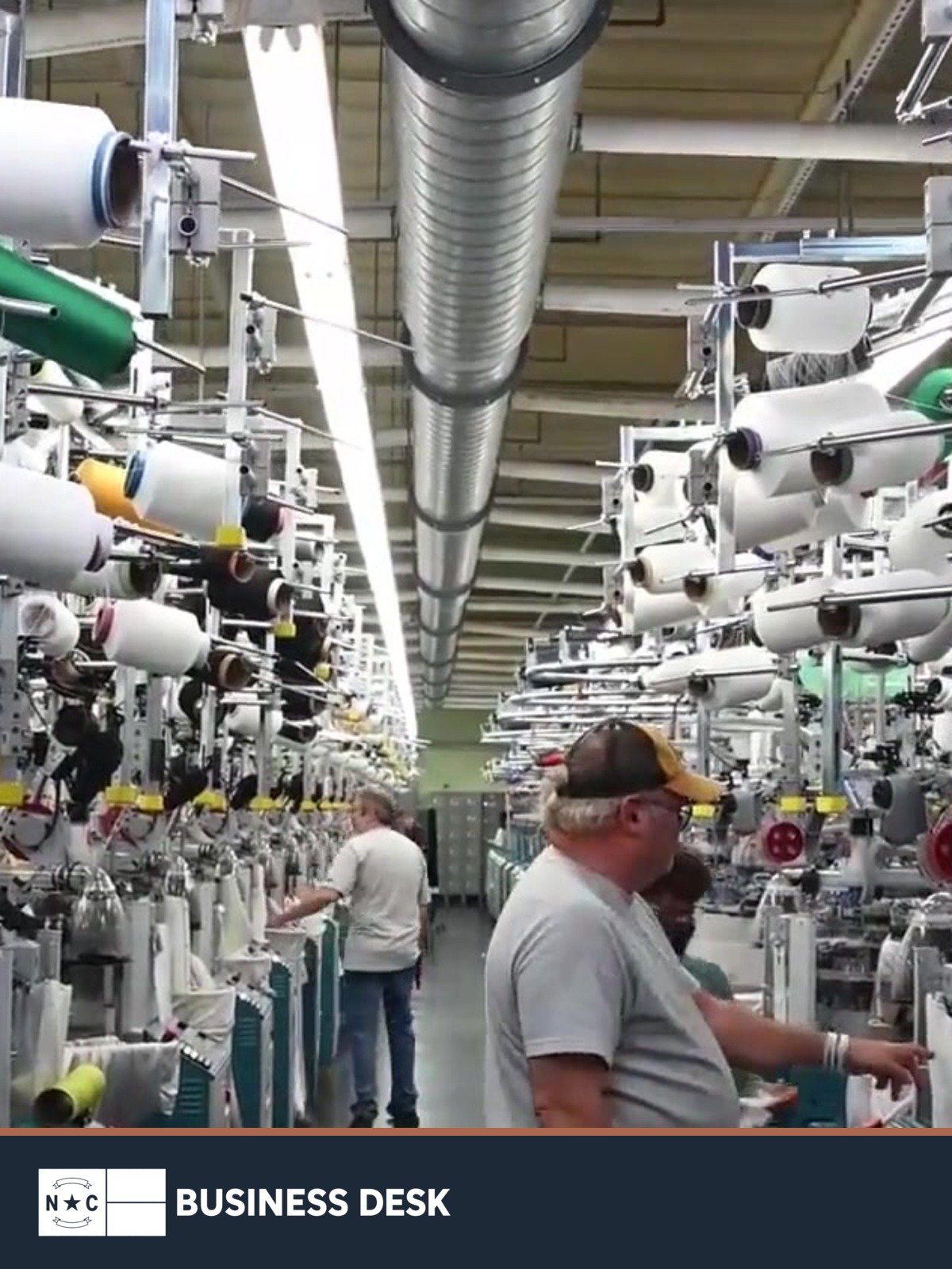 File image from Bossong Hosiery's official factory video showing employees and knitting machines at its Asheboro plant.