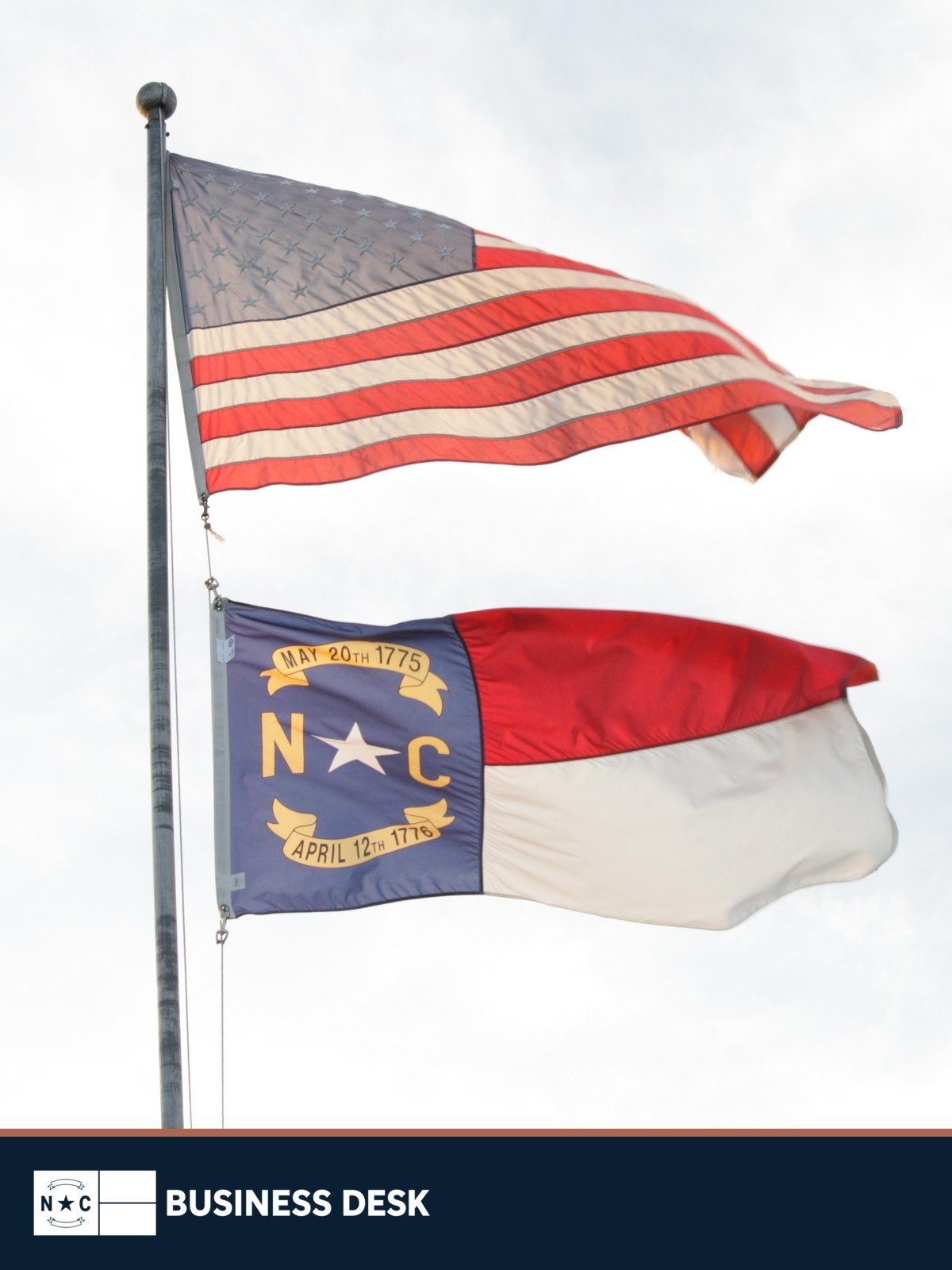 United States and North Carolina flags fly from a flagpole in Andrews above the NC Business Desk footer.