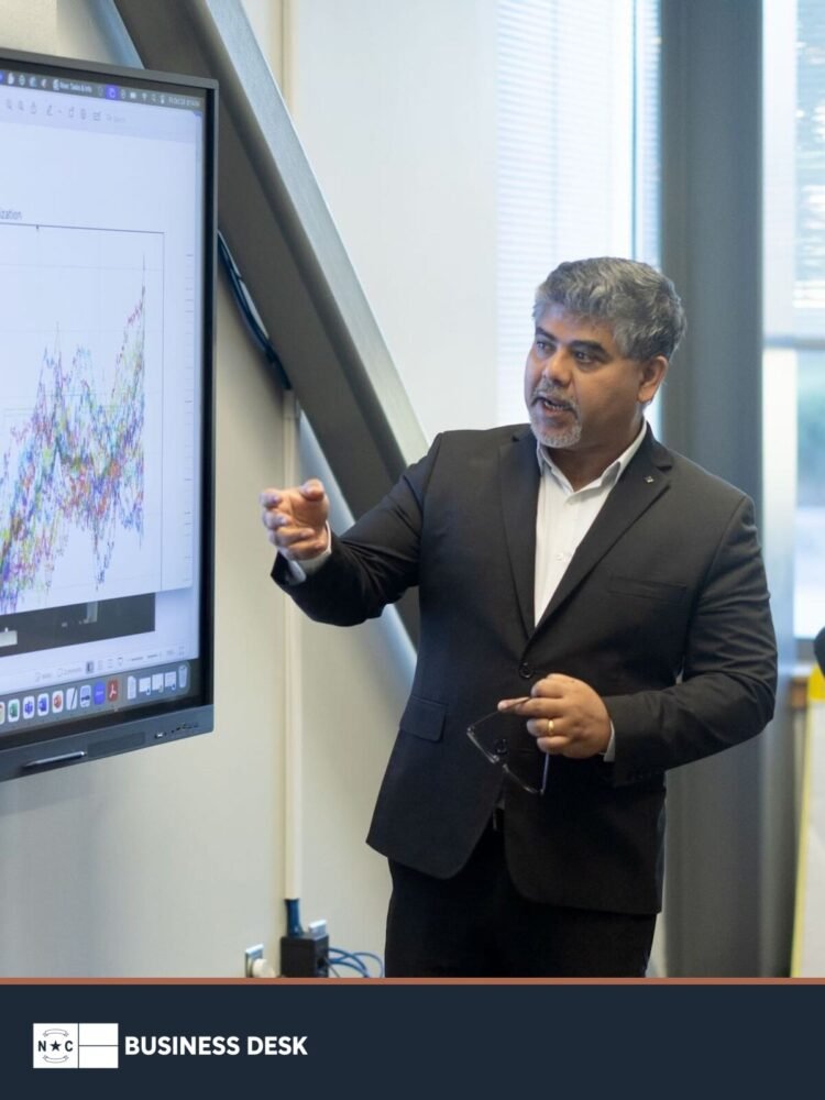 Fayetteville State professor Sambit Bhattacharya discusses AI research beside a data visualization above the NC Business Desk footer.