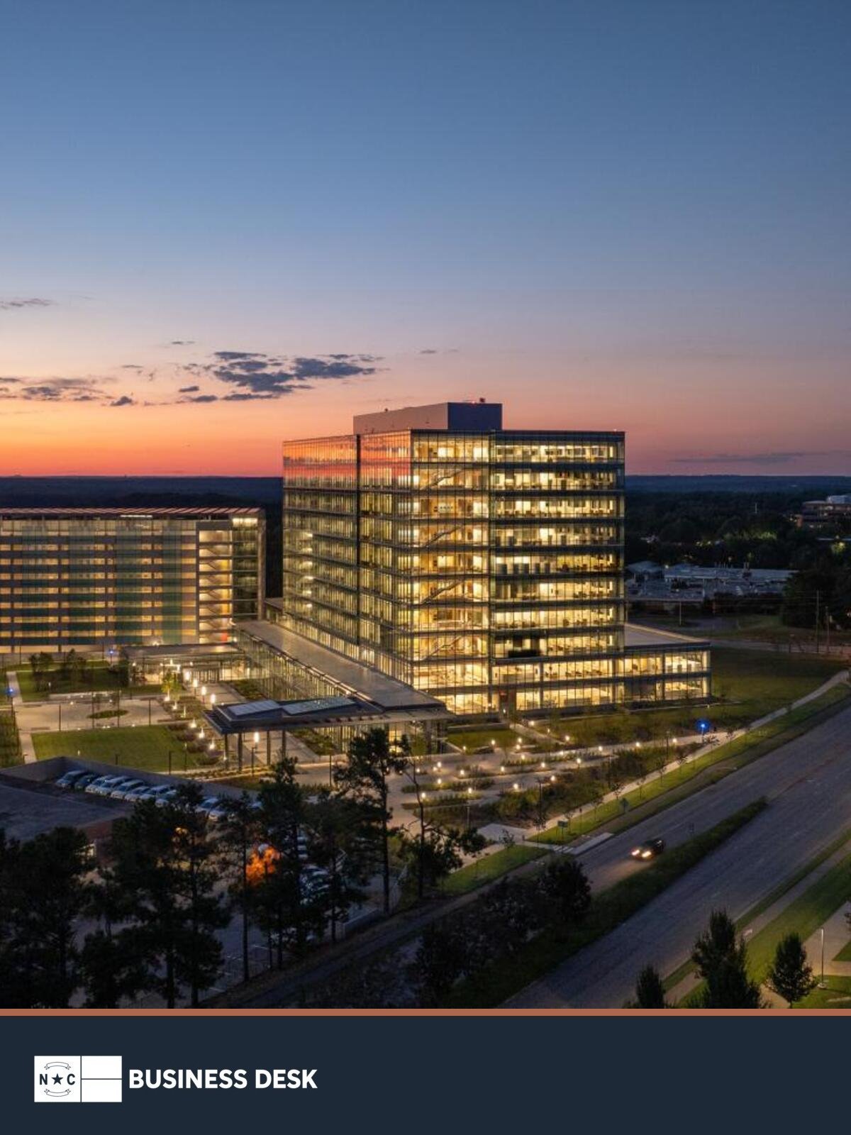 Official N.C. Department of Health and Human Services campus in Raleigh at dusk above the NC Business Desk footer.