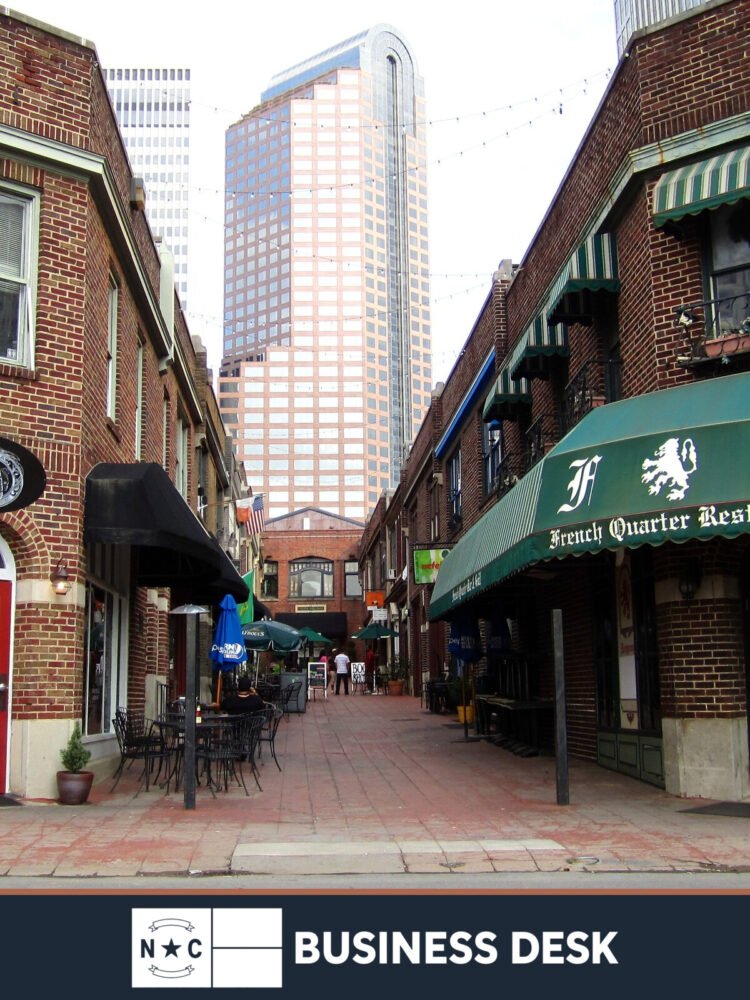 2012 photograph of Wells Fargo Tower rising above Latta Arcade in Charlotte, cropped above the NC Business Desk footer.