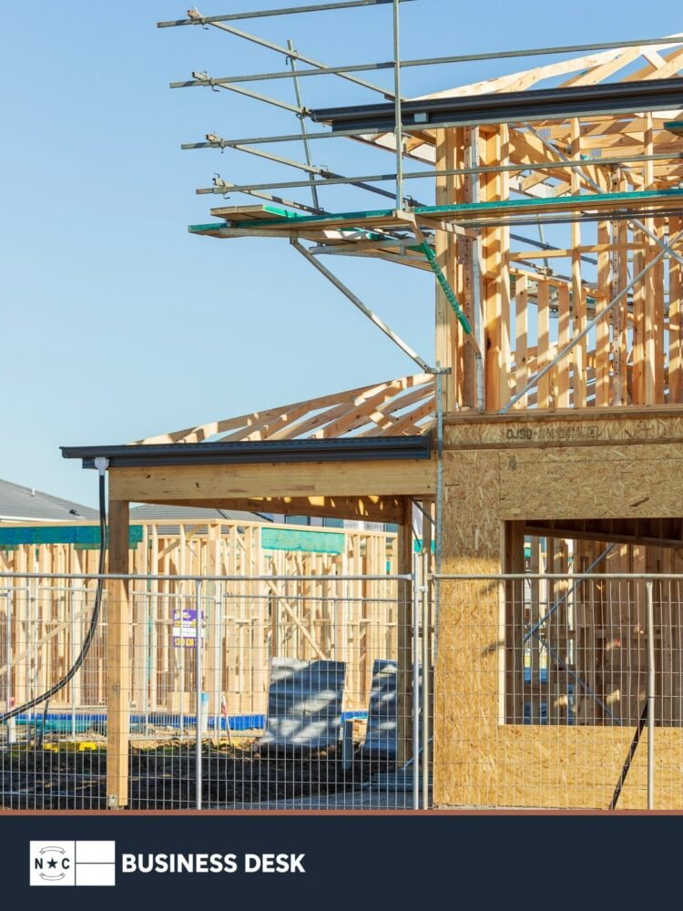 Wood framing and scaffolding at a residential construction site, shown as contextual imagery for planned housing development.