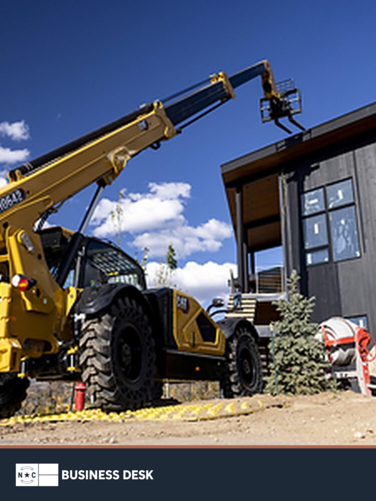 Cat telehandler operating at a construction site.