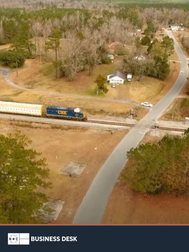 Aerial view of a CSX train crossing the Mid-Atlantic Industrial Rail Park megasite in Brunswick County above the approved NC Business Desk footer.