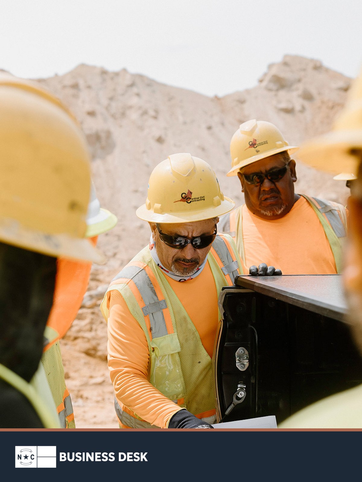 Cardinal Infrastructure construction workers review plans at an active civil site.