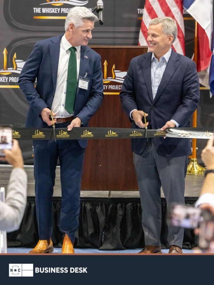 Gov. Josh Stein and Whiskey Project Group CEO Darren Schuback cut the ribbon at the company’s Edenton manufacturing hub above the NC Business Desk footer.